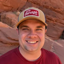 Sean Robb smiling in a trucker cap in front of red rock